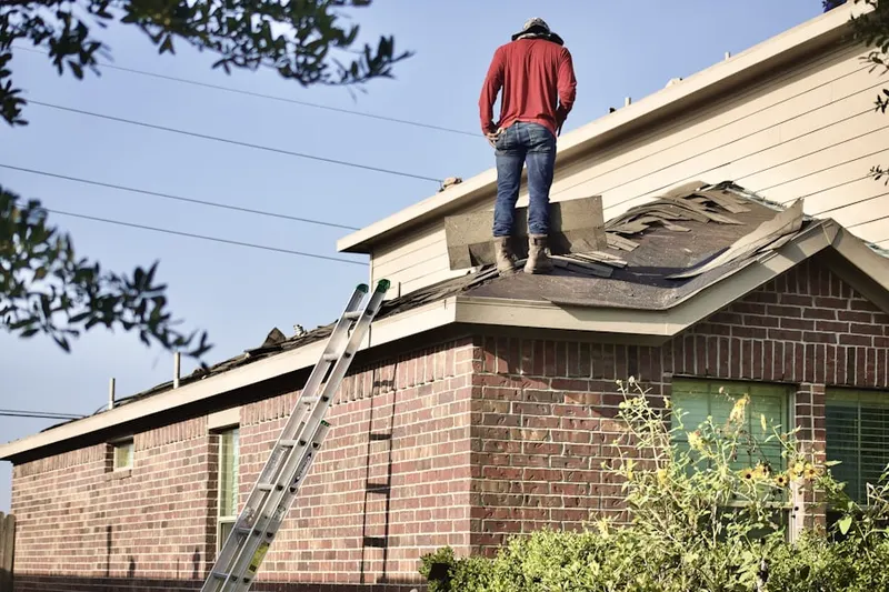 Professional roofer working on a residential roof in Sand Hill